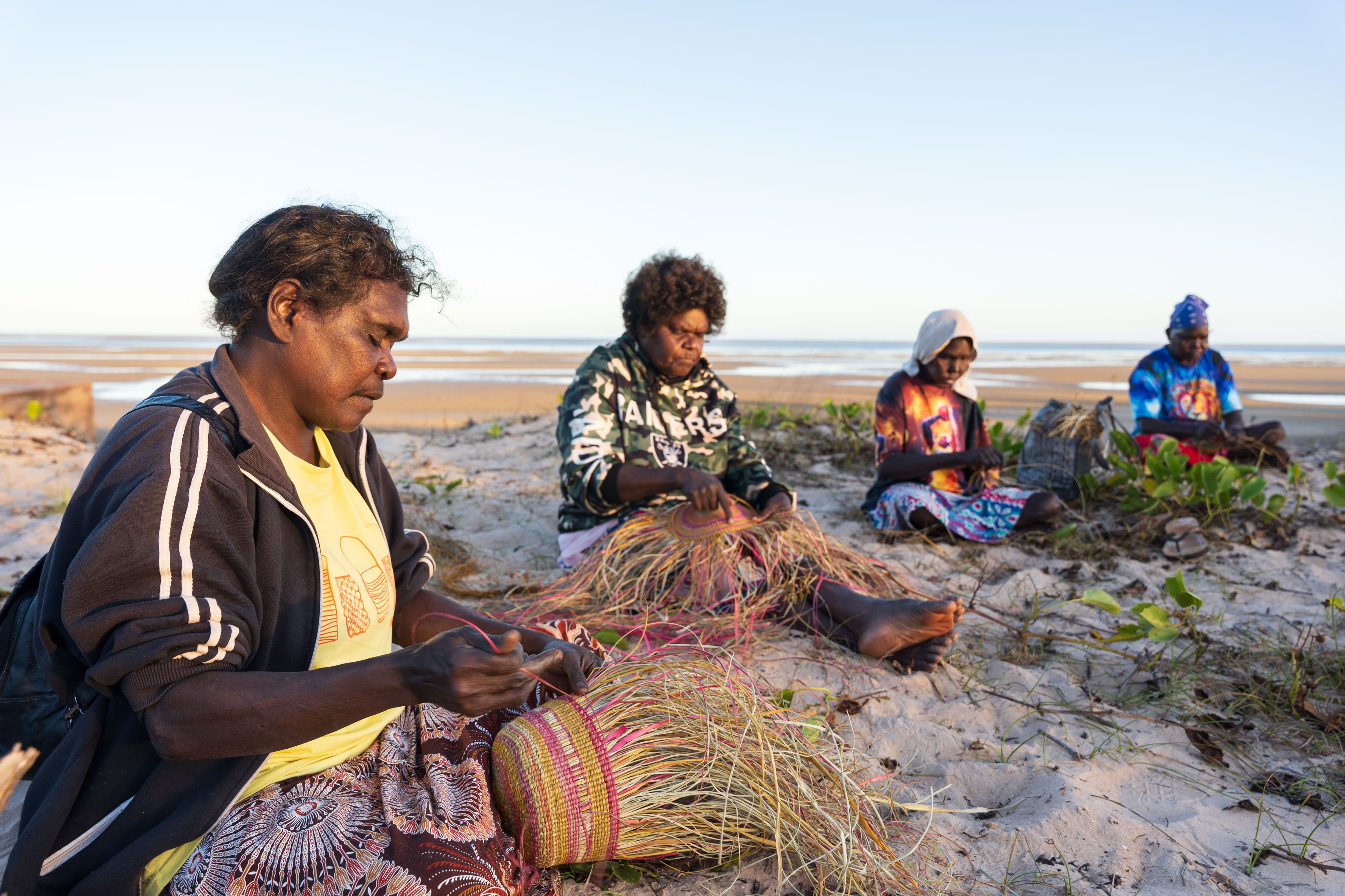 Weaving circle on the beach. Photo: Pouria Zoughi, Courtesy of Numbulwar Numburindi Arts.